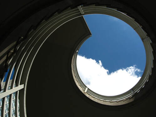photo of a spiral staircase looking upward toward the sky